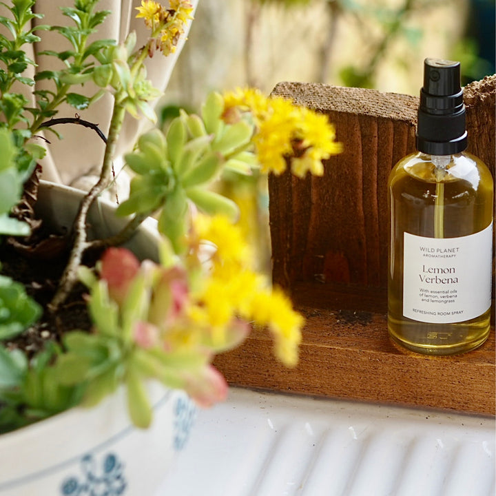 Lemon Verbena Essential Oil Room Spray next to white kitchen sink and bowl of flowers
