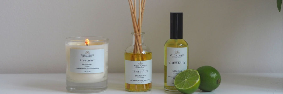 Limelight home fragrance candle, reed diffuser and room spray next to fresh lime sliced in half Wild Planet Aromatherapy blog