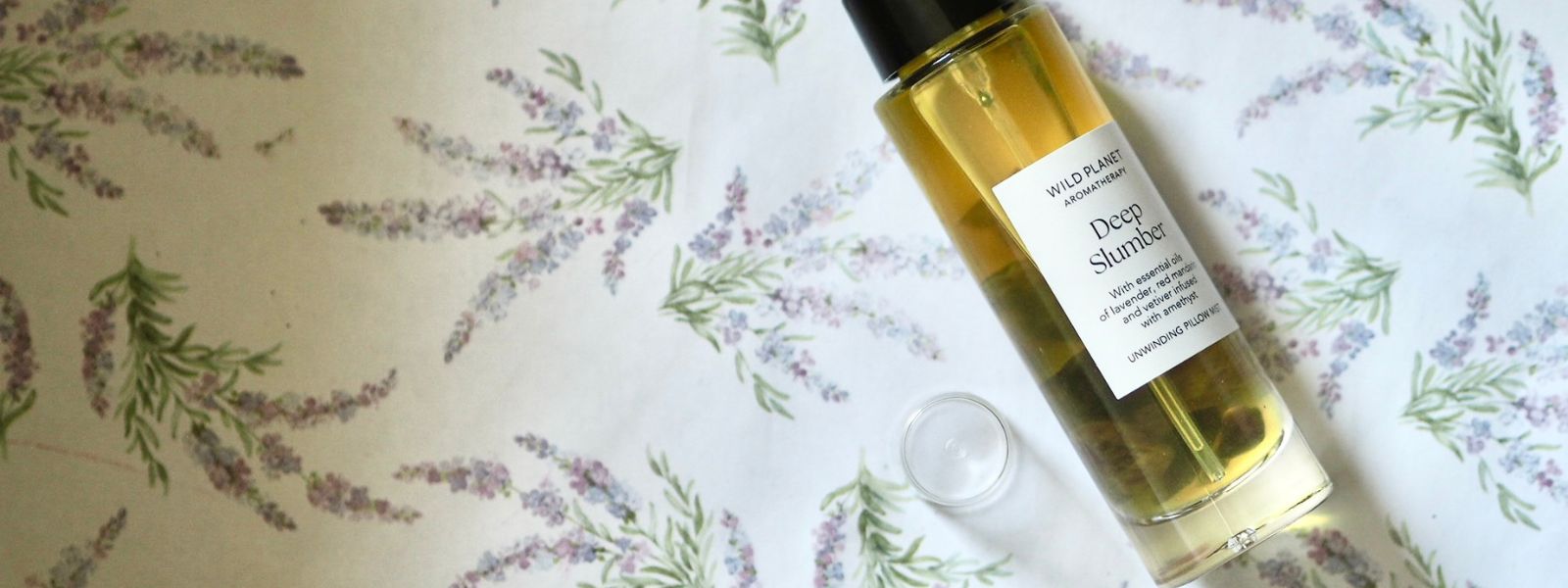 Deep Slumber Pillow Mist flatlay on lavender sprig surface with lid by Wild Planet Aromatherapy