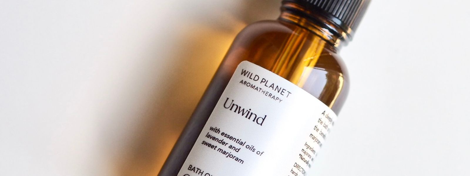Unwind Bath Oil in amber glass bottle on white background by Wild Planet Aromatherapy