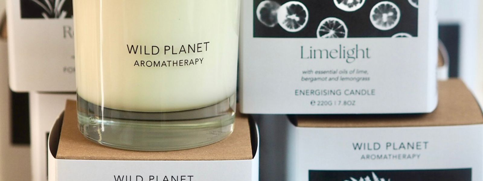 Candle on top of branded candle boxes by Wild Planet Aromatherapy