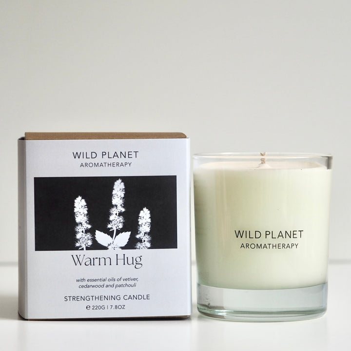 Wild Planet Aromatherapy warming vegan natural soy wax candle next to natural eco friendly box 