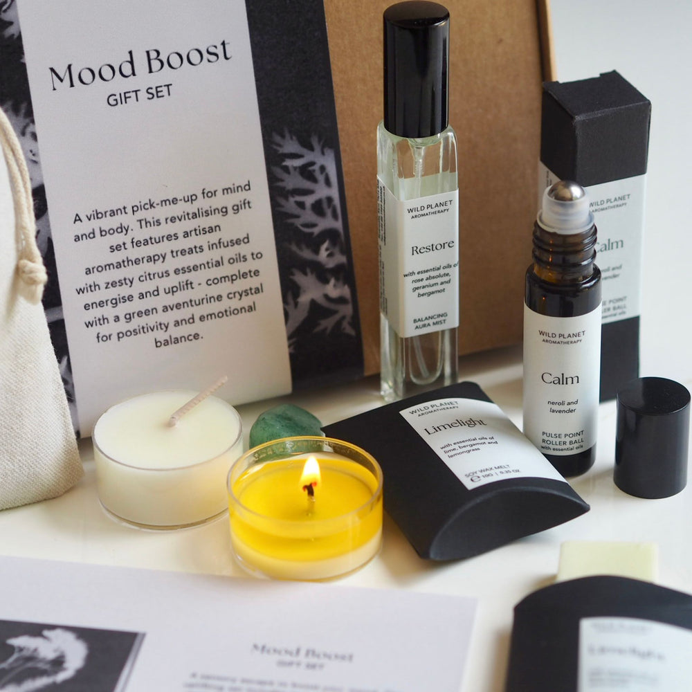 Close up of Mood Boost Letterbox Gift Set, bath salts, oils, tea lights and wax melts on white table