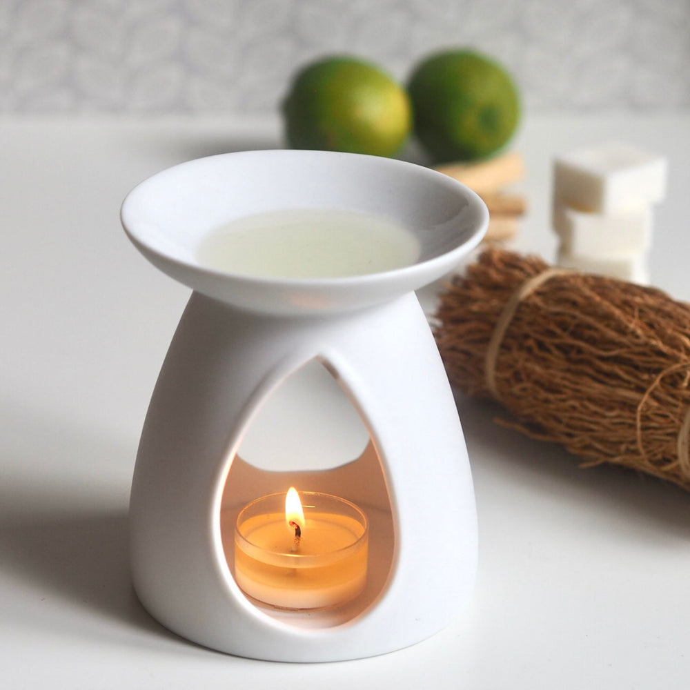 White ceramic oil burner with lit tea light heating Wild Planet Aromatherapy luxury wax melt